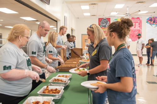 Teachers select food from the table while members of Team Mainstreet assist at DeLand High School