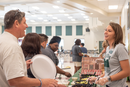 A woman smiles and greets a teacher during the DeLand High School teacher lunch hosted by Mainstreet Community Bank