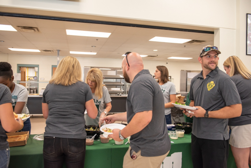 A male teacher looks on as other teachers get lunch from members of Team Mainstreet at DeLand High School