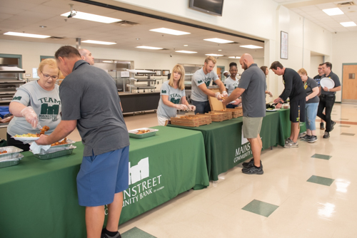 A group of Mainstreet Community Bank employees serve lunch to teachers at DeLand High School.